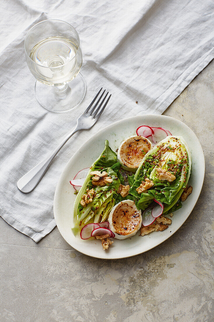 Flambéed goat's cheese with walnuts on leaf salad