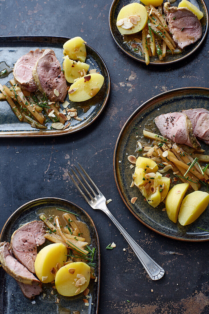 Leg of lamb in herb marinade with vegetables, chips and salad