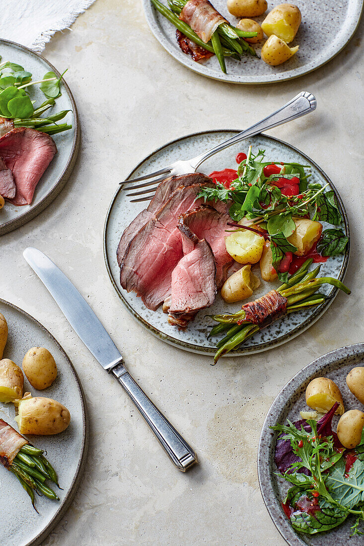 Lacquered roast beef with potatoes, bacon beans and wild herb salad
