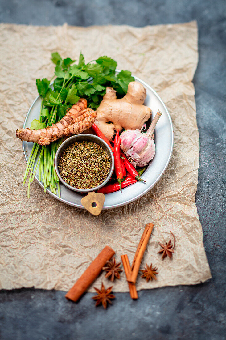 Assorted spices and herbs - coriander, ginger, turmeric, garlic, chili, dried basil, cloves, cinnamon