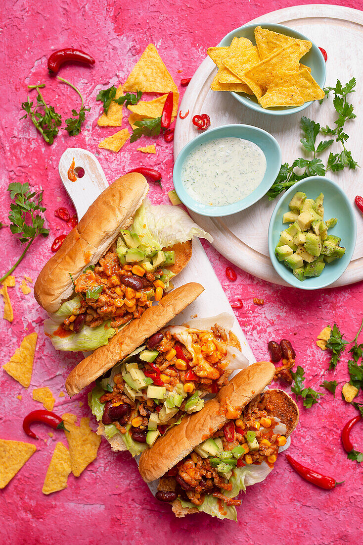 Hot Dogs mit mexikanischer Hackfleischsauce, Mais, Avocado und roten Bohnen