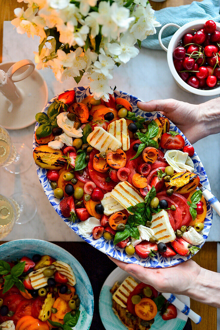 Bunter Tomatensalat mit Halloumi, Burrata, Früchten und Oliven