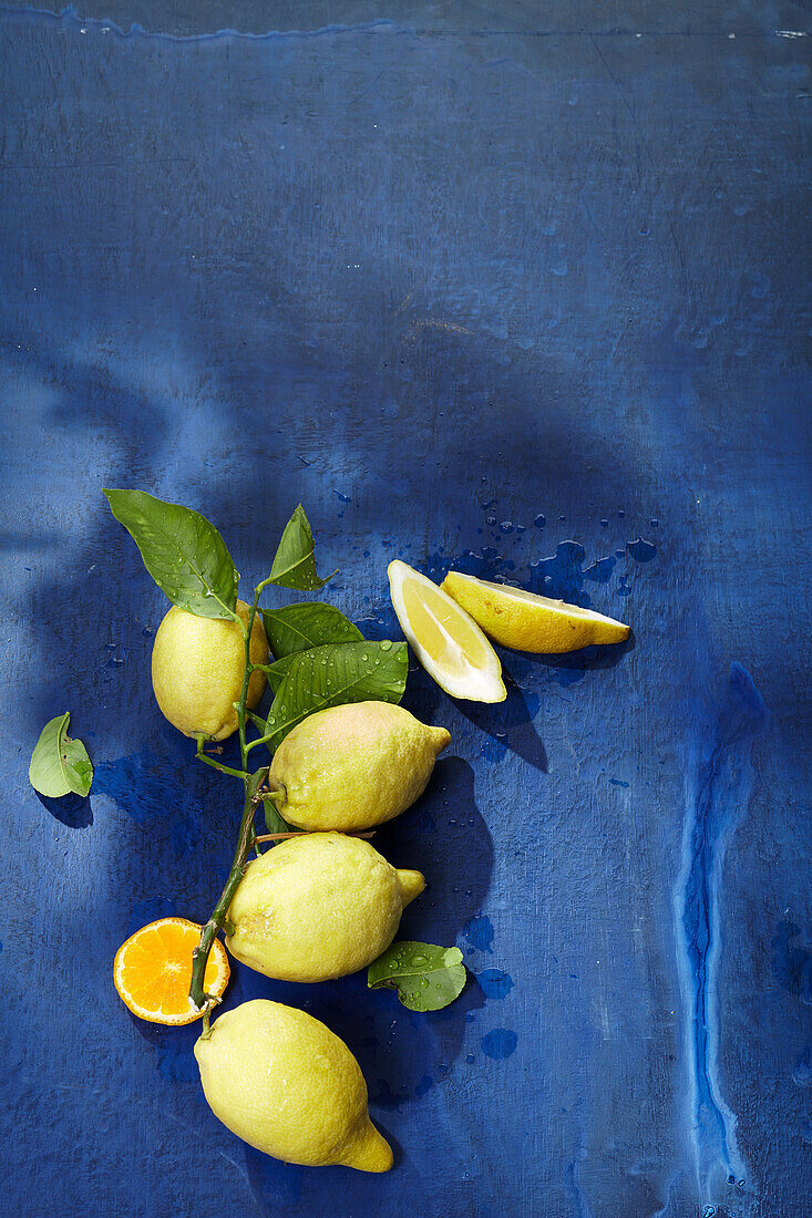 Stillleben mit Zitronen und Orange auf blauem Untergrund