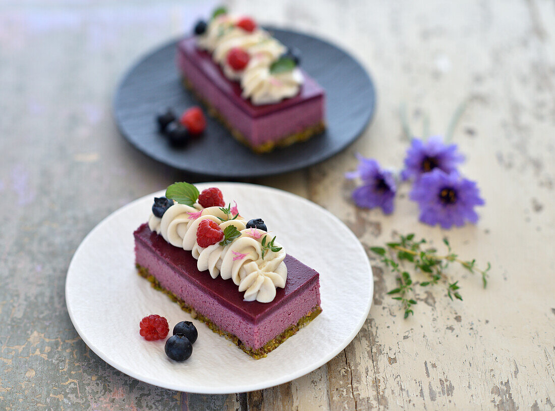 Vegane Himbeermousse-Törtchen mit Pistazienboden und Heidelbeerguss