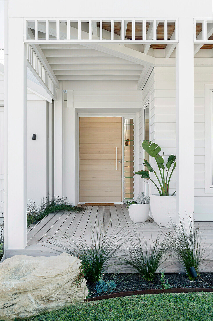 Entrance area with light wooden door and deck