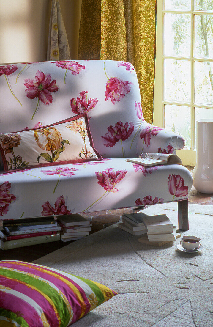 Sofa mit Blumenprint, darunter Bücher