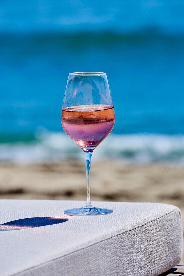 Ein Glas Roséwein auf Tisch am Meer