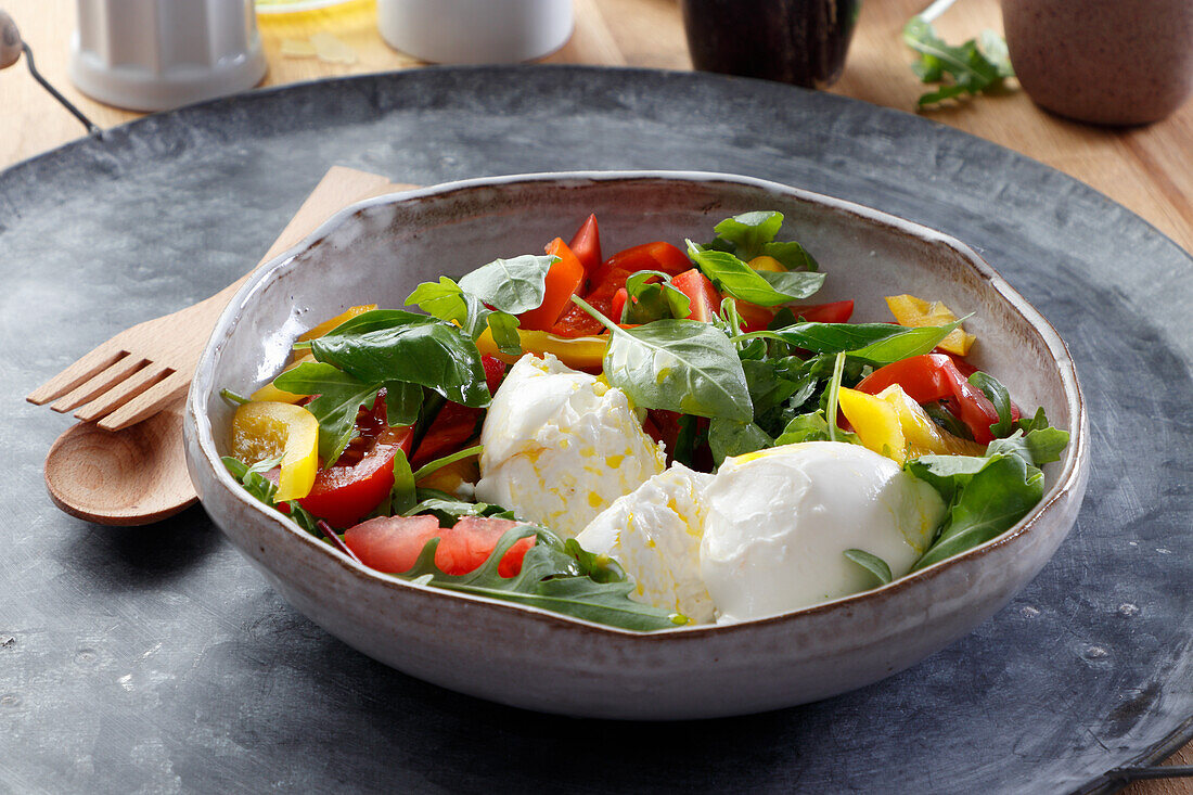 Salad of tomatoes, peppers, and edible flowers with burrata