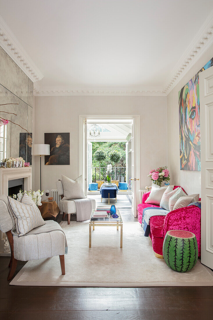 Pink sofa and light upholstered armchairs in the living room with fireplace