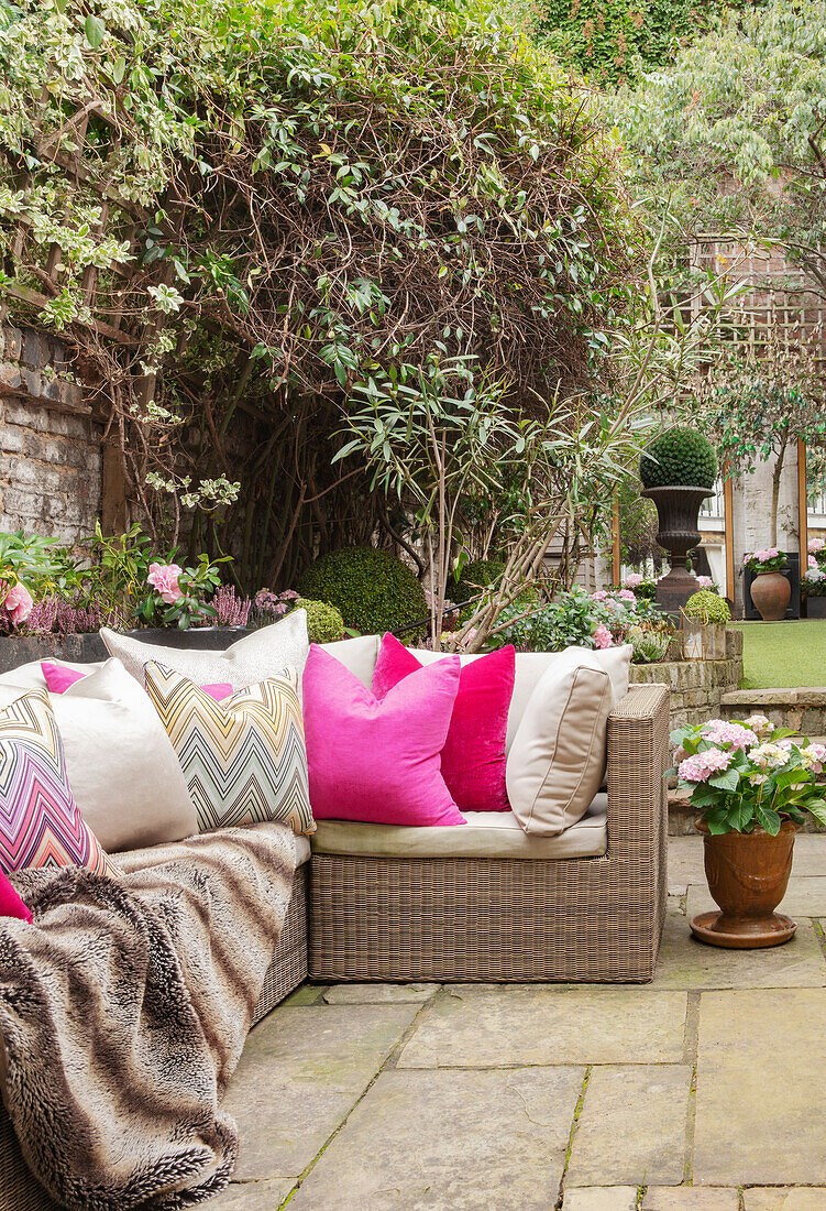 Outdoor-Sofa mit Kissen und Decke auf der Terrasse
