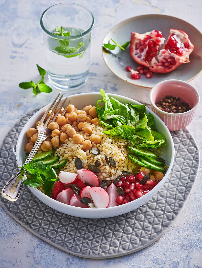 Bowl with bulgur, chickpeas, radishes and pomegranate seeds