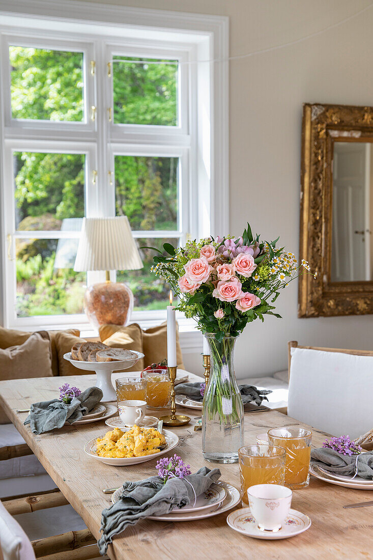 Gedeckter Tisch mit Rosenstrauß