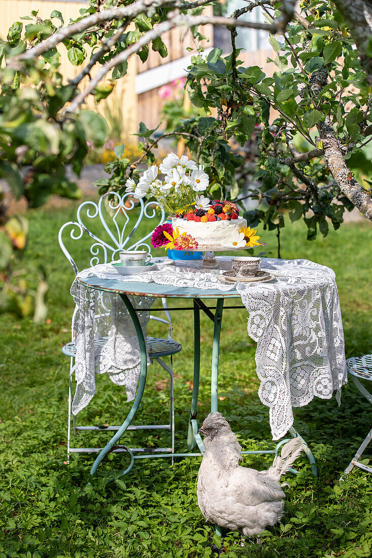 Festlicher Kuchen mit Früchten auf Gartentisch