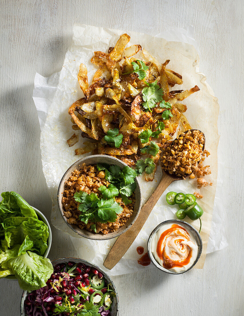 Gebratene Kartoffelschalen mit Falafelhack, Rotkohl, Tahini-Creme