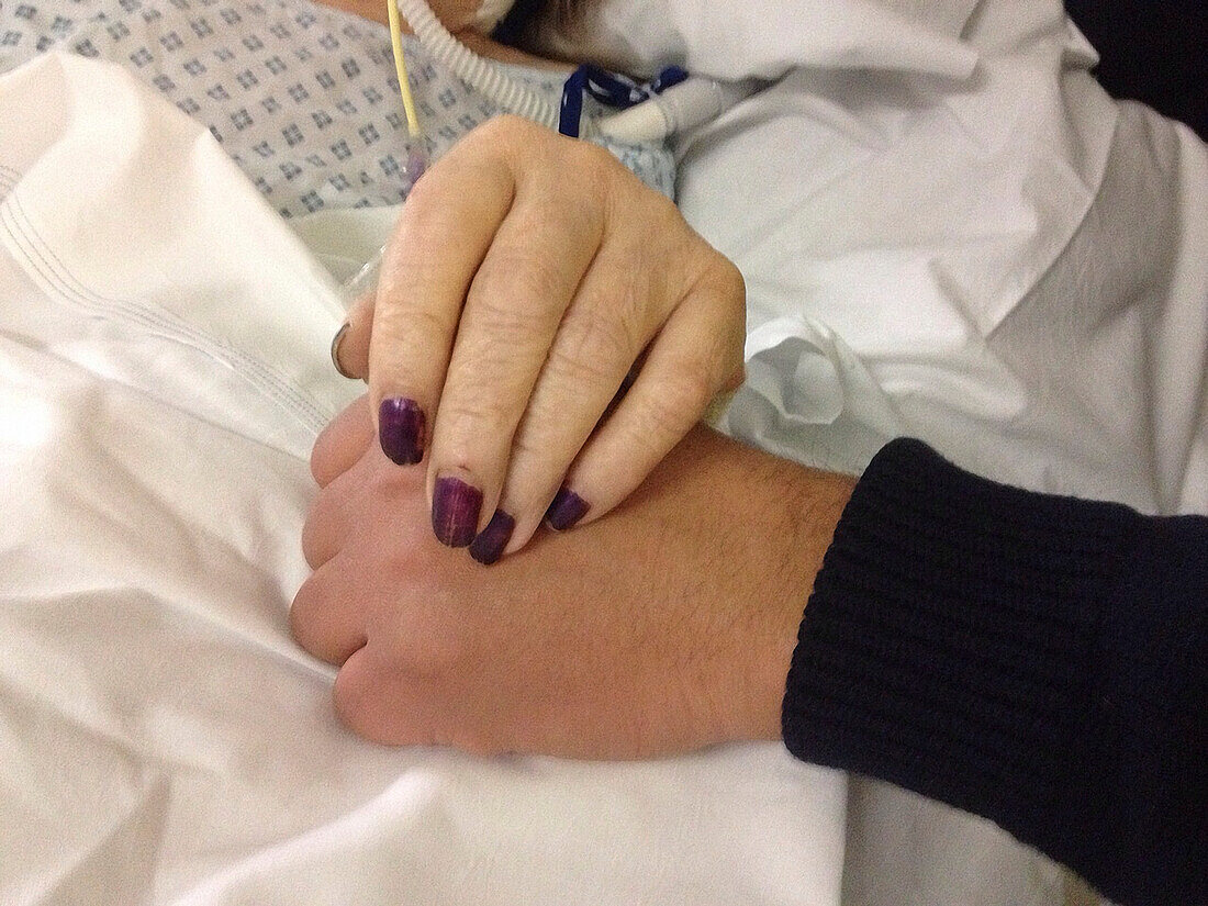 Hands of a relative comforting an ill patient