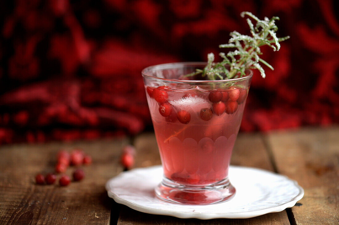 Cranberry-Tonic, garniert mit gezuckertem Rosmarinzweig