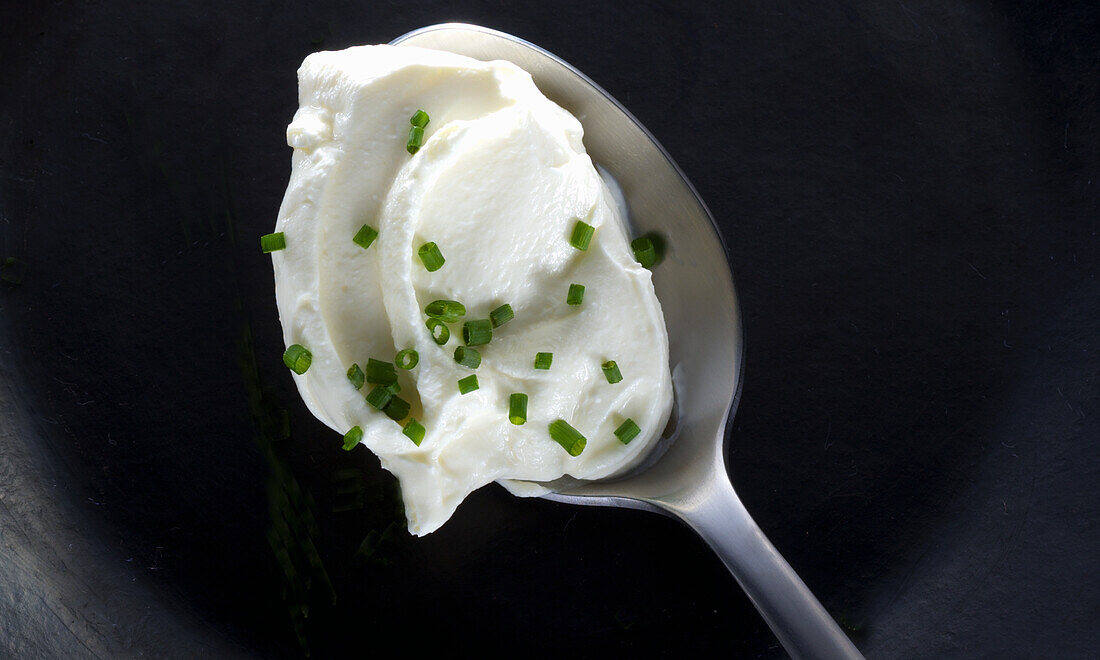 Cream cheese with chives on a spoon