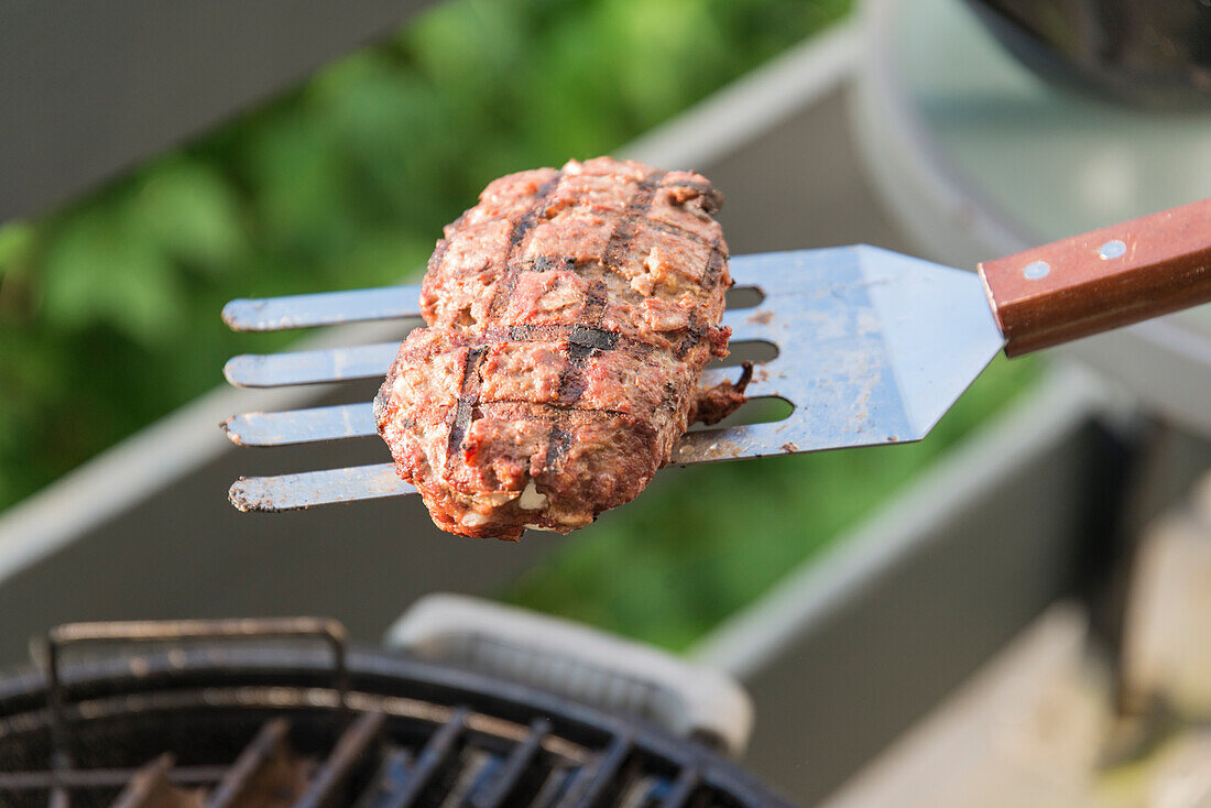 Grilling bifteki (Greek meatball)