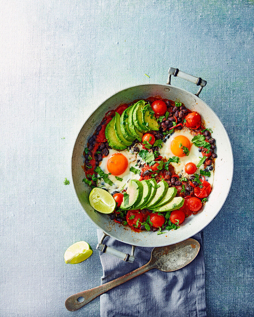 Avocado mit schwarzen Bohnen, Spiegeleiern und Tomaten