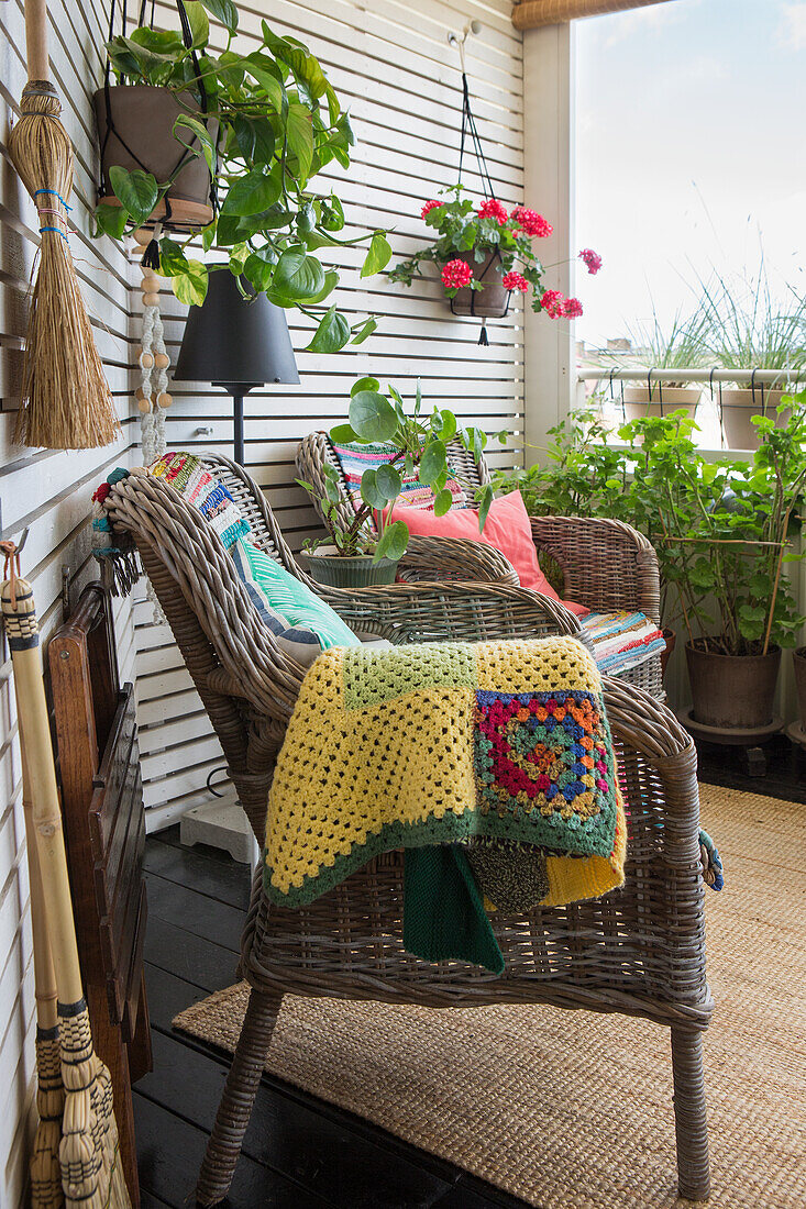 Gemütliche Korbstühle mit Häkeldecke auf der Terrasse