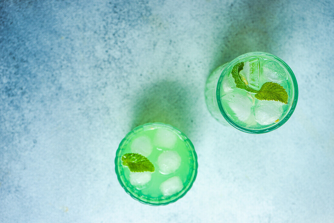 Mojito cocktail with mint and lemon served in the crystal glass on concrete table