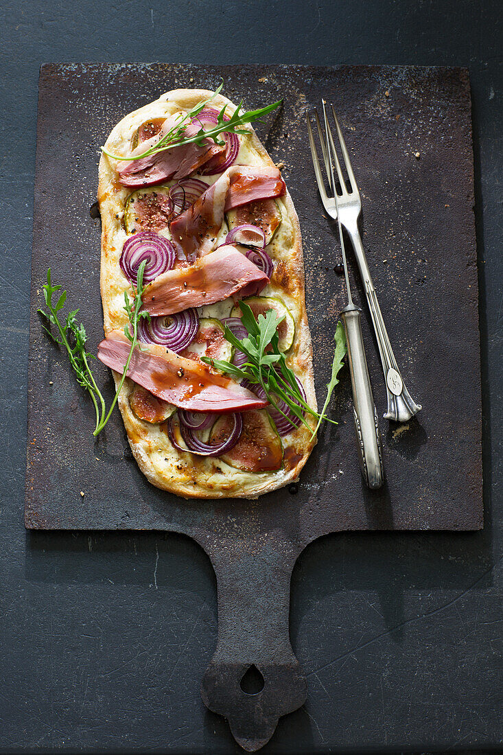 Tarte flambée with meat, red onions, and figs
