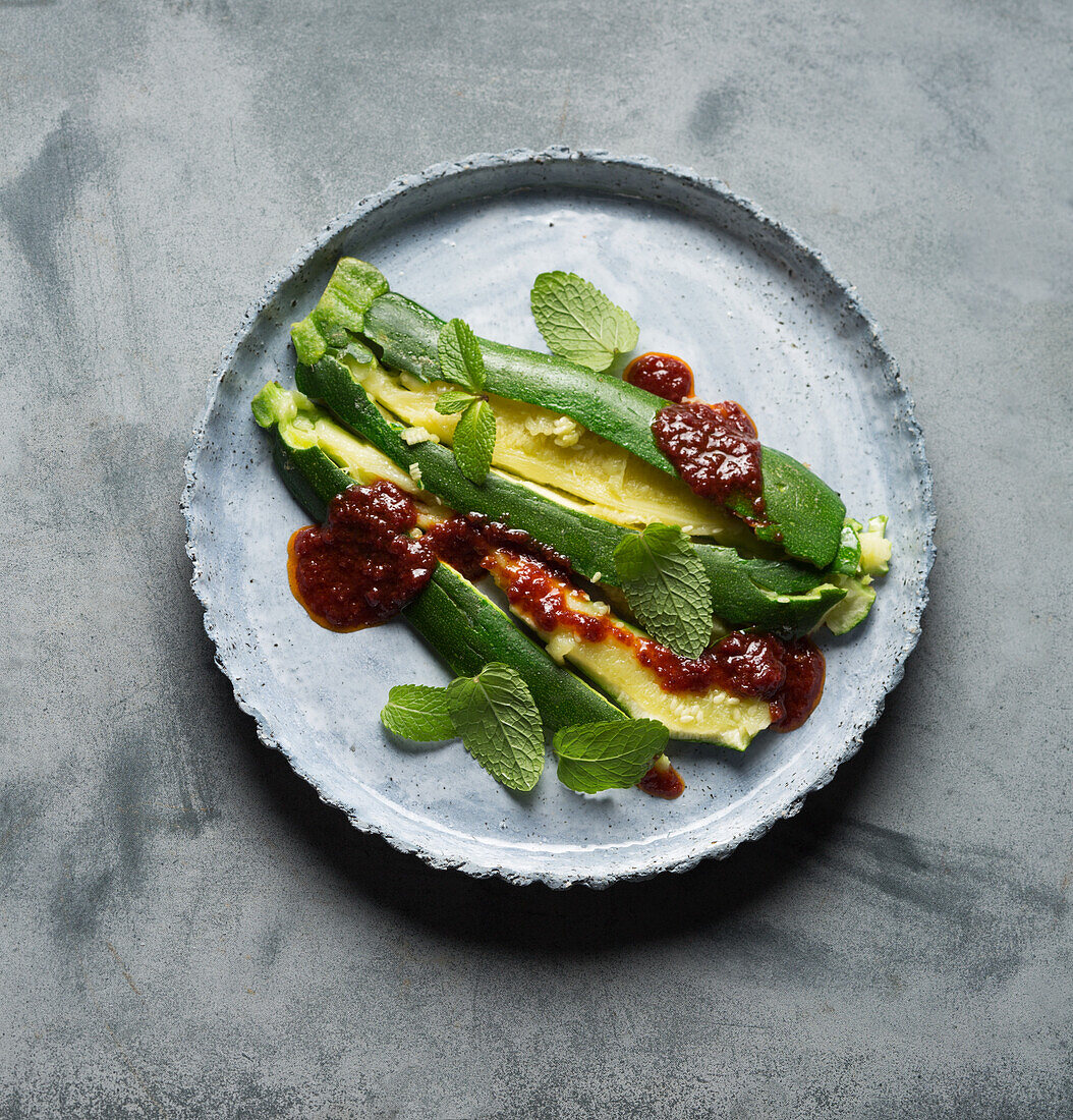 Vegan zucchini with harissa, cherry jam, and mint