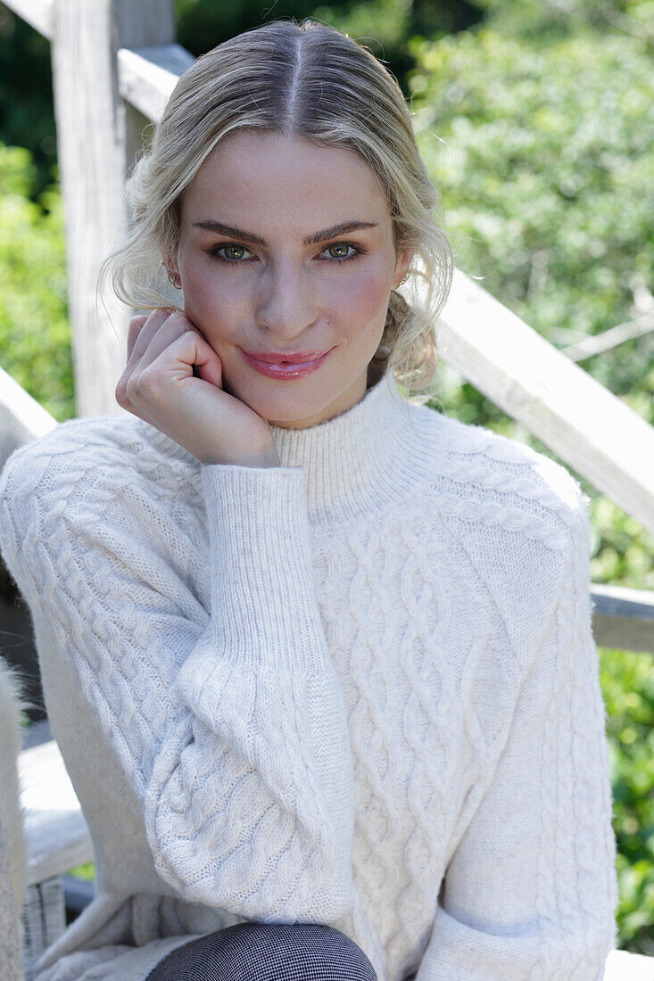 Young blonde woman in a white knitted sweater