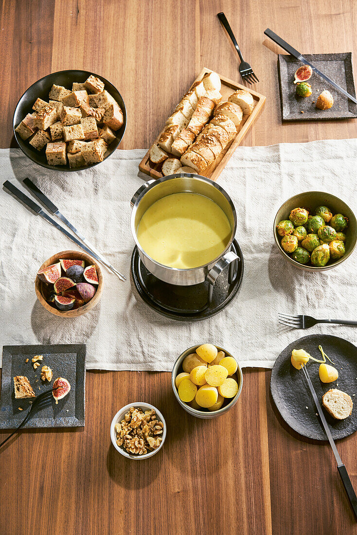 Cheese and gin fondue with pretzel rolls, walnut bread, figs, and Brussels sprouts