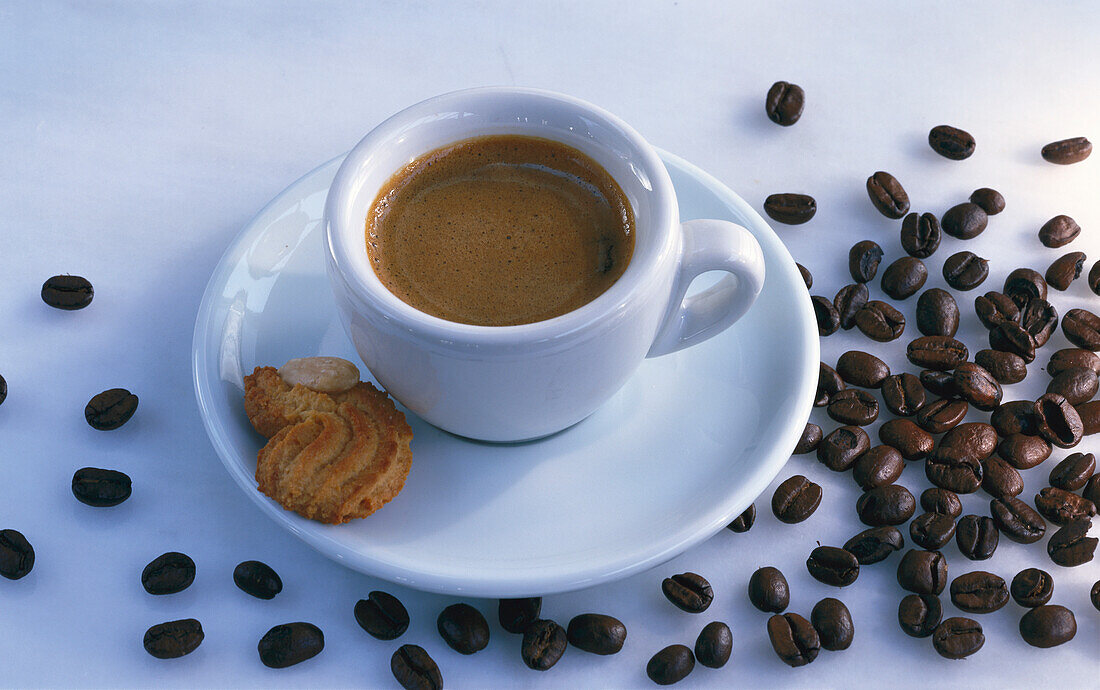 Eine Tasse Espresso daneben Kaffeebohnen