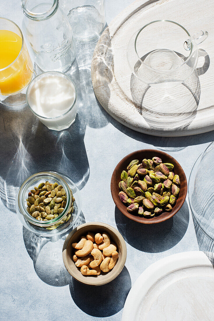 Overhead view of bowls with nuts and glasses on table