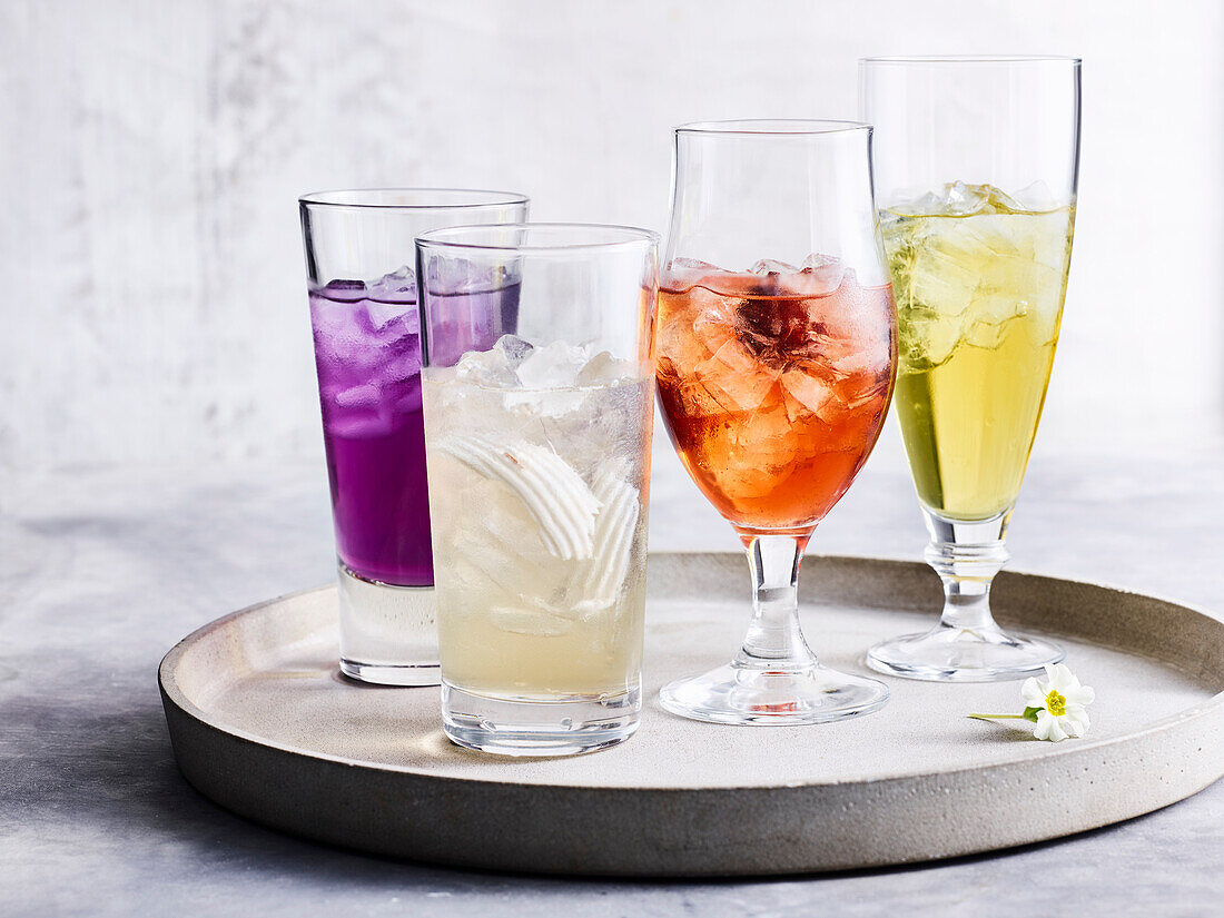 Vier verschiedene Getränke in Gläsern auf Tablett