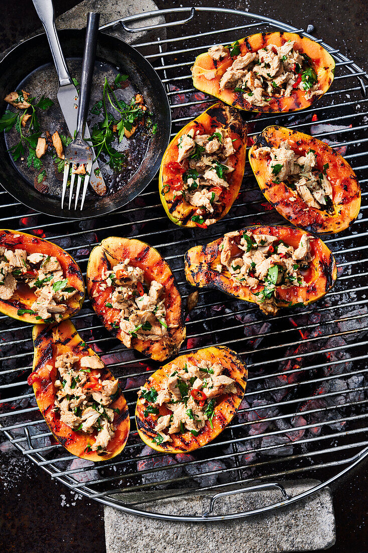 Grilled papayas stuffed with lime chicken on a grill rack