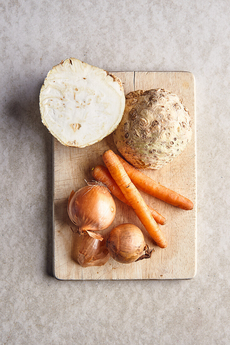 Vegetables for soup on wooden cutting board