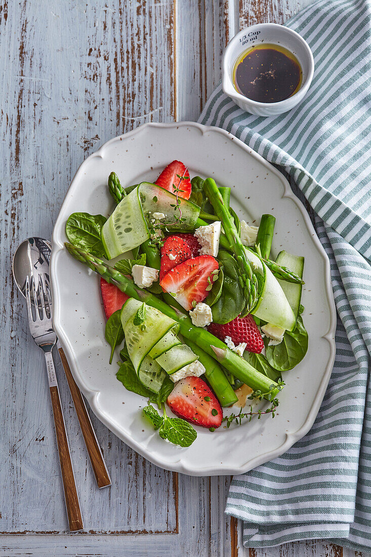 Green asparagus salad with feta cheese and strawberries