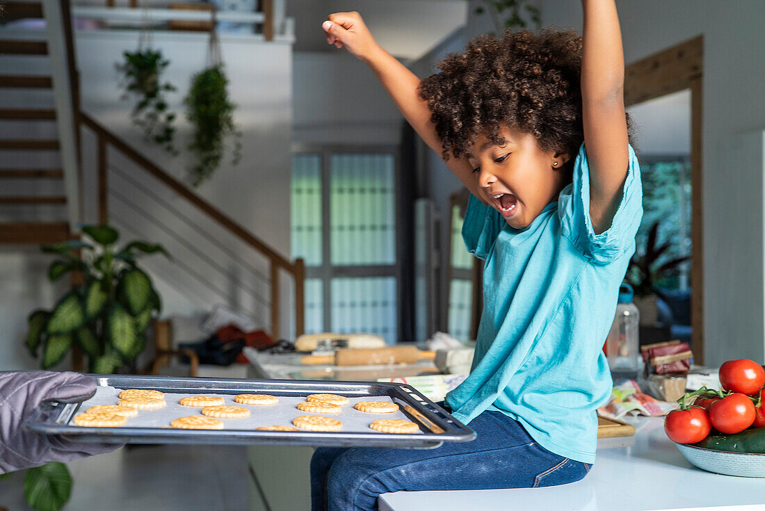 Kind freut sich über frisch gebackene Plätzchen