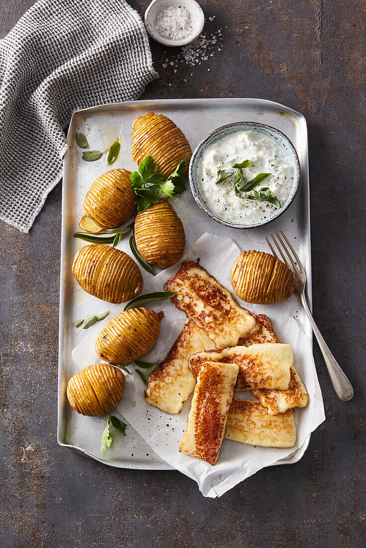 Baked potatoes with herbs, pan fried halloumi and tzatziki