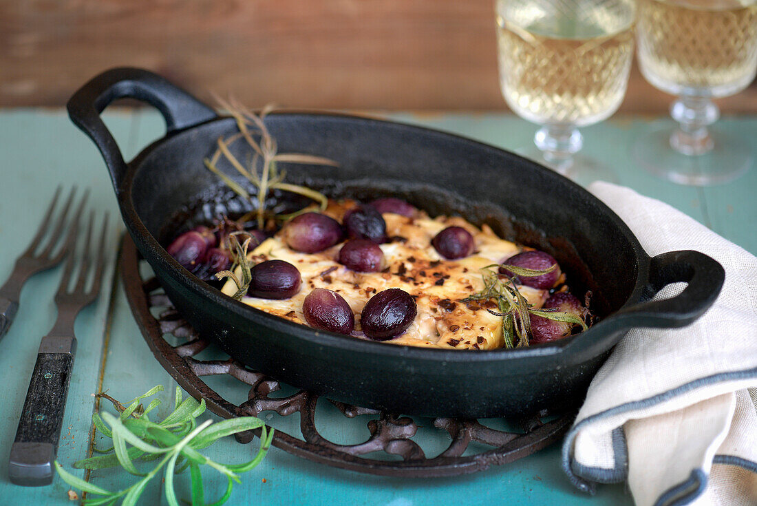 Baked feta cheese with roasted grapes and rosemary