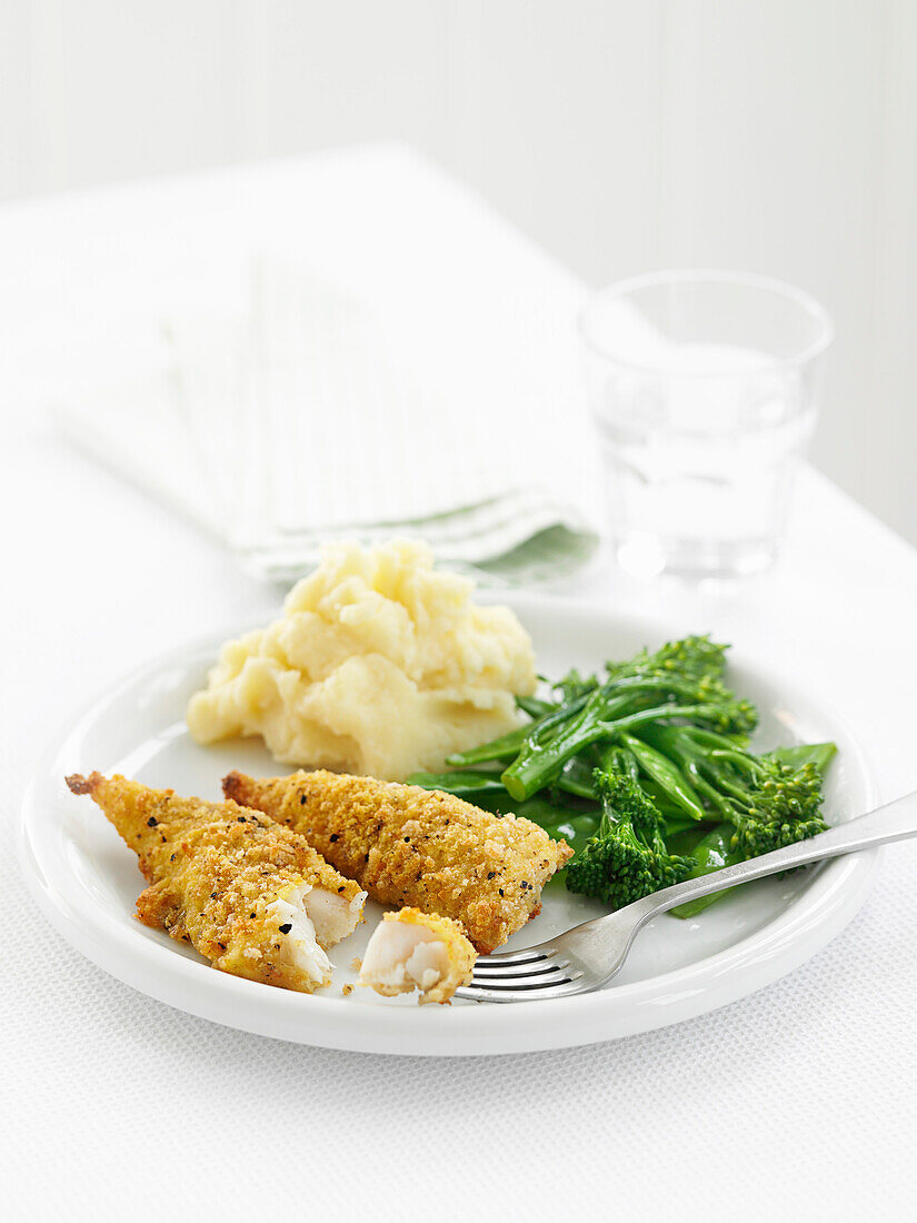 Breaded fish fingers with mashed potatoes and broccoli