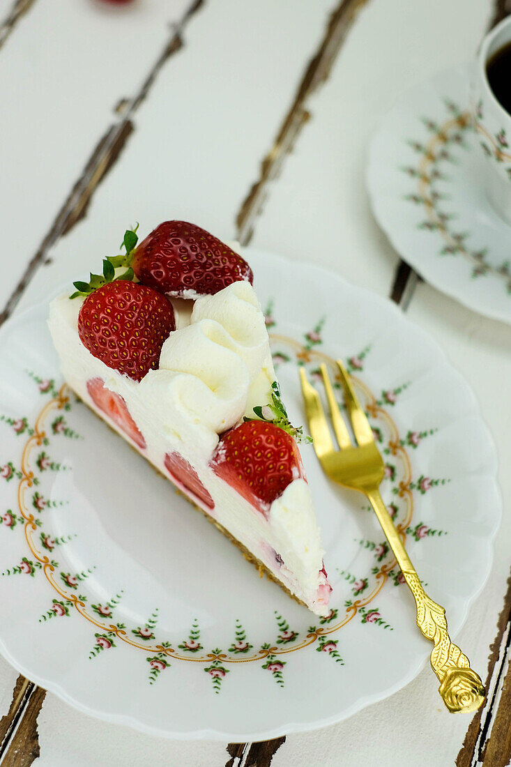 Ein Stück Erdbeer-Käsesahne-Torte auf Teller
