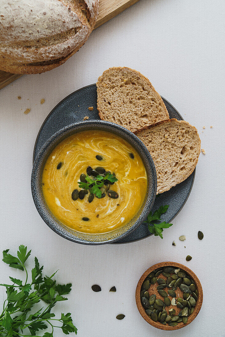 Cream of pumpkin soup with pumpkin seeds and bread