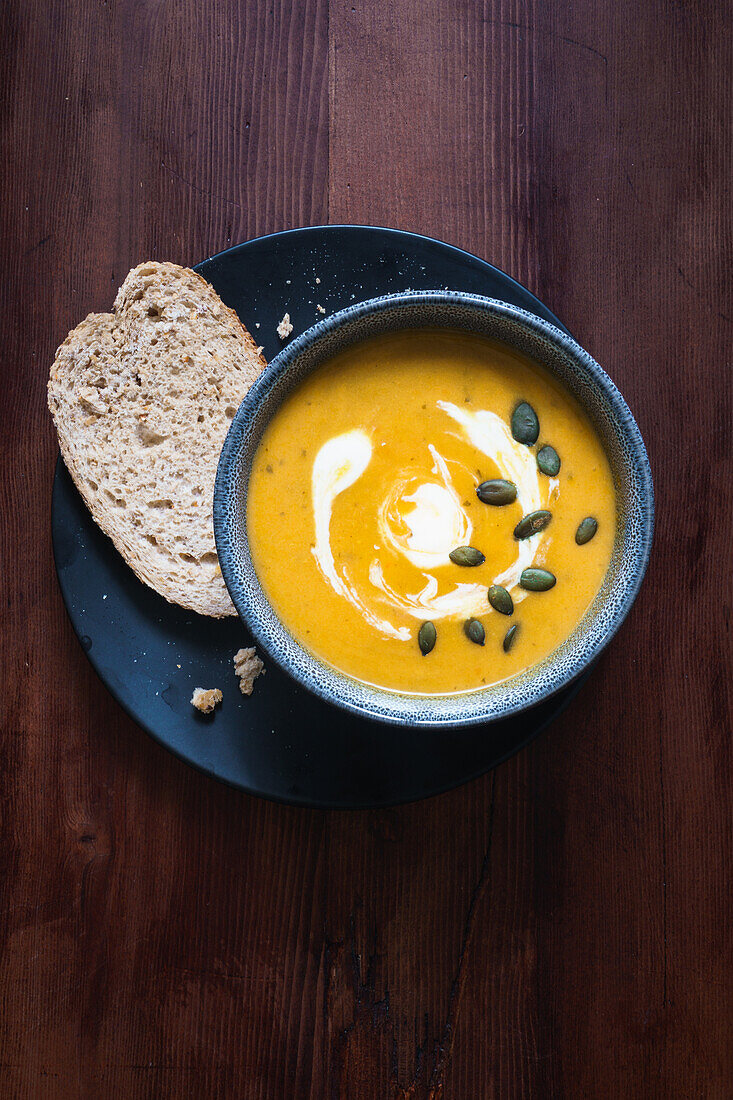 Cream of pumpkin soup with pumpkin seeds and bread