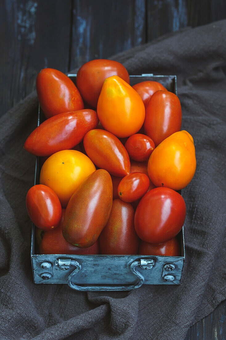 Various tomatoes in a metal box
