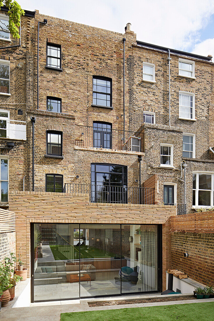 View from the garden to the rear facade of a brick house