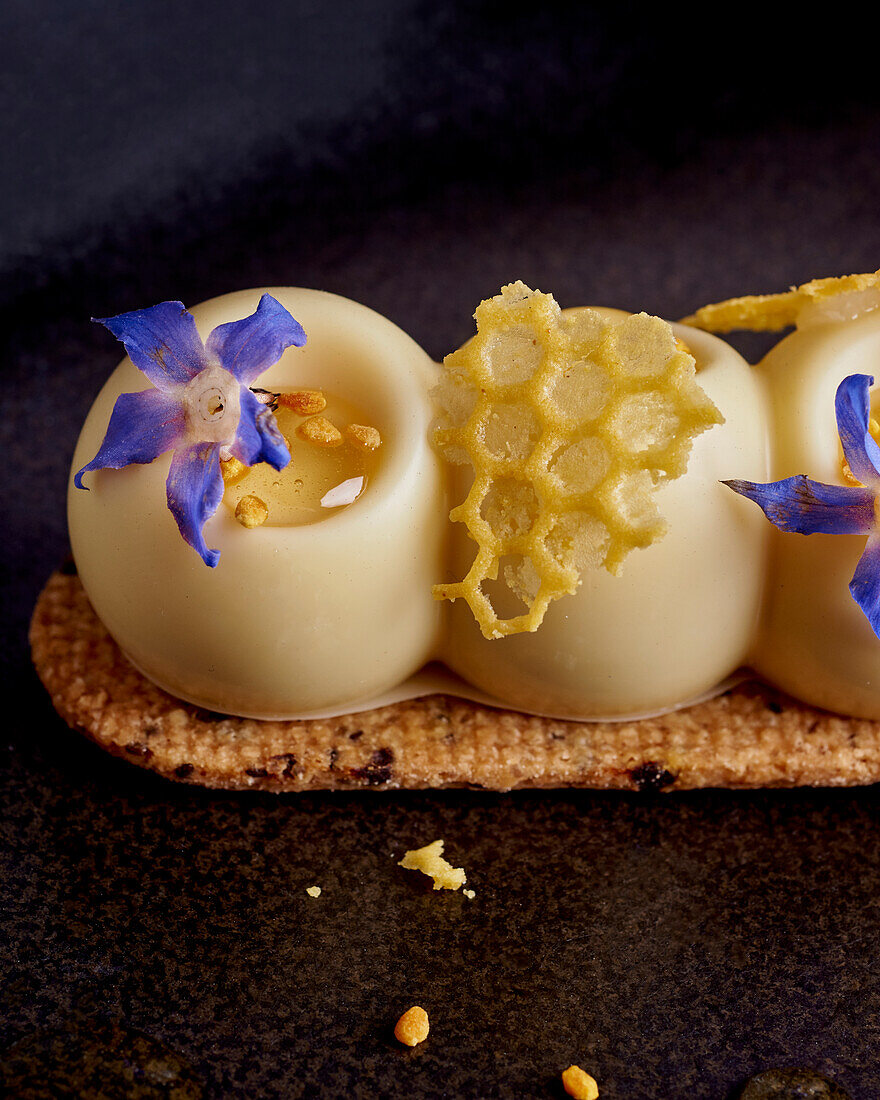 Honey dessert with white chocolate and blue flowers (close-up)