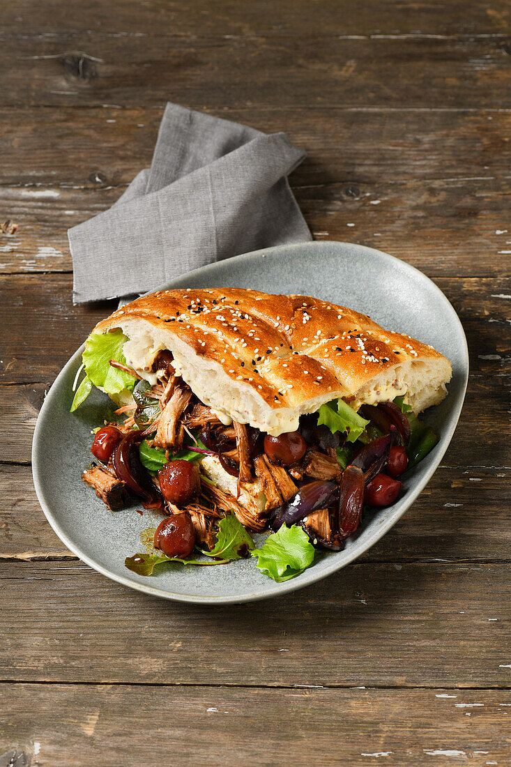 Pita bread with pulled pork and sour cherries