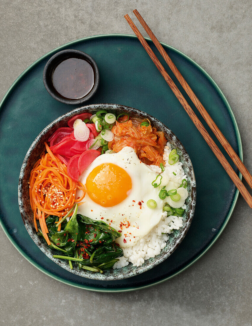 Koreanische Bibimbap Bowl mit marinierten Radieschen und Spiegelei