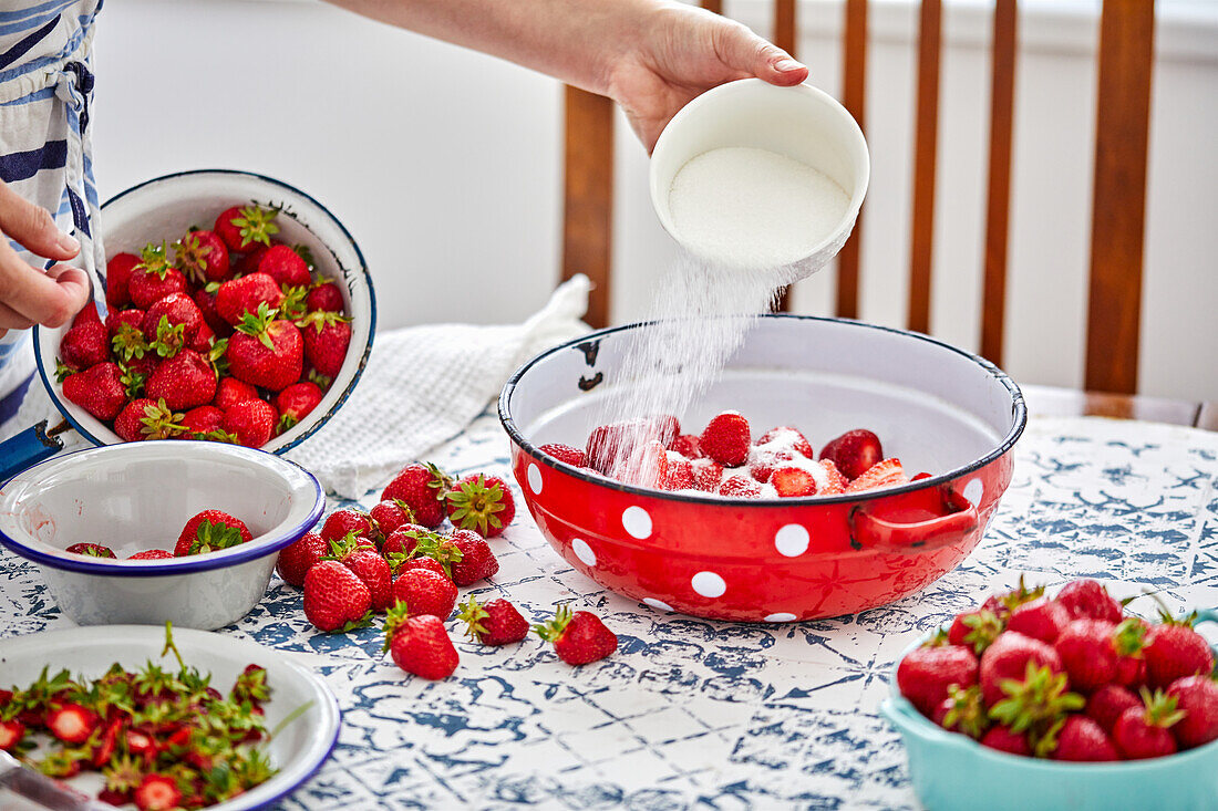 Making strawberry jam - sprinkle strawberries with sugar