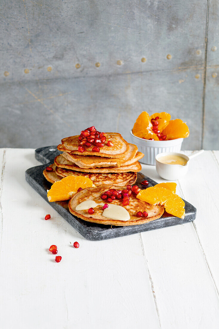 Buckwheat pancakes with clementines, pomegranate seeds and almond cream