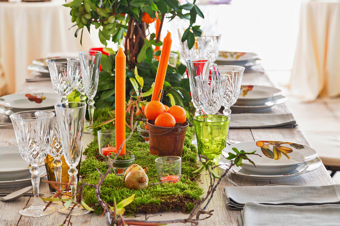 Festlich gedeckter Tisch, mit Moos und Kerzen dekoriert